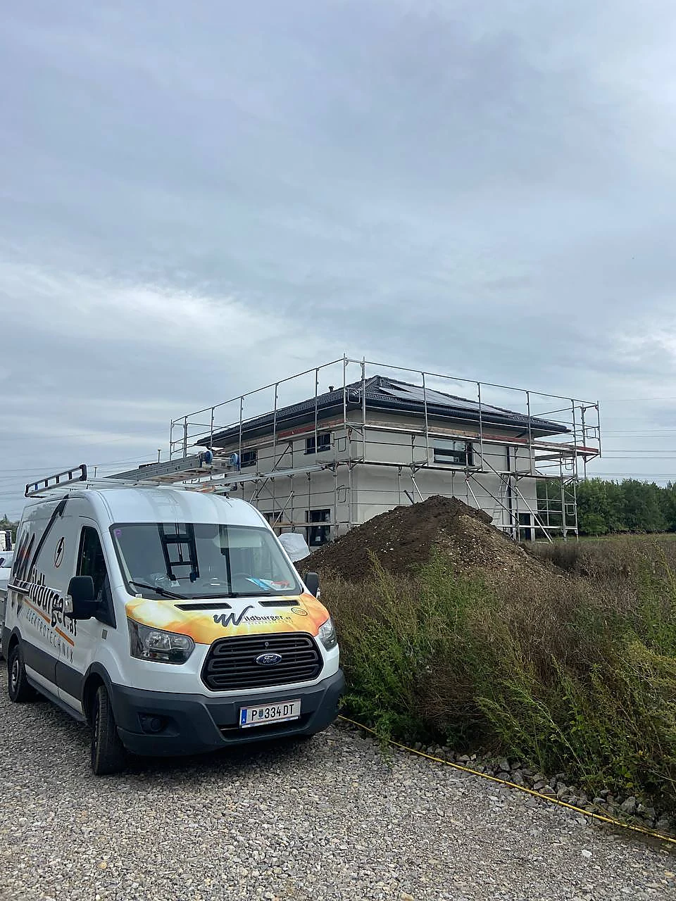 Firmenfahrzeug an einer Baustelle mit PV-Bezug